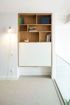 an empty room with a book shelf on the wall and a lamp next to it