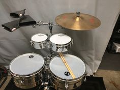 a close up of a drum set on a stage with a white sheet in the background