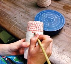 a person is working on some pottery at a table