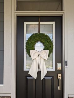 the front door is decorated with a wreath and a large bow on it's side