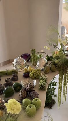 a table topped with lots of different types of fruits and vegetables next to a window