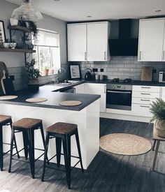 an image of a kitchen setting with stools on the counter and island in the middle