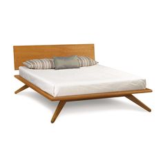 a bed that has some pillows on top of it and is made out of wood