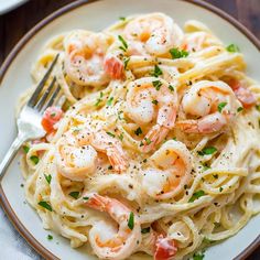 a plate of pasta with shrimp and parsley