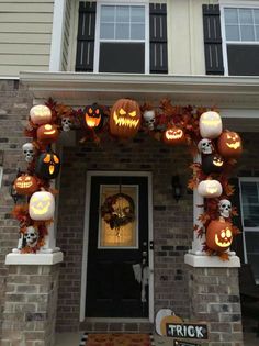 a house decorated for halloween with pumpkins and jack - o'- lantern decorations