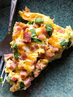 a slice of ham and cheese quiche on a blue plate with a fork