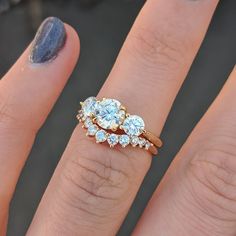 a woman's hand with three rings on it and two diamonds in the middle