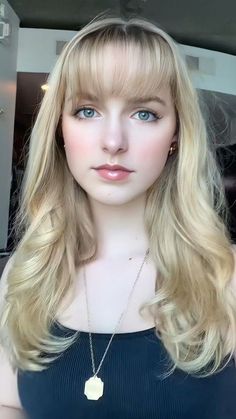 a blonde wig with bangs and blue eyes