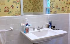 a white sink sitting under a bathroom mirror