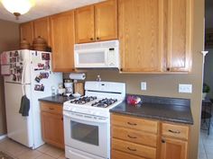 a white stove top oven sitting inside of a kitchen next to a refrigerator freezer