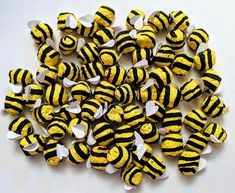 a pile of yellow and black striped buttons on a white surface with holes in the middle