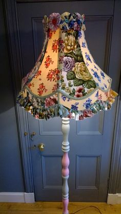 a lamp that is on top of a wooden floor in front of a blue door