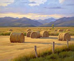 a painting of hay bales in an open field with mountains in the back ground