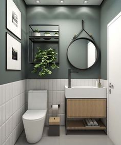 a bathroom with a toilet, sink and plant in the corner on the wall next to the mirror