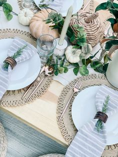 the table is set with white plates and silverware