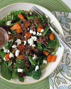 a salad with spinach, carrots, and feta cheese on a plate