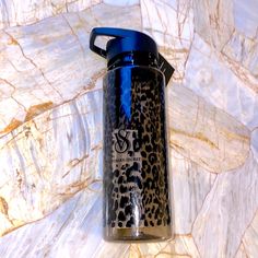 a blue and black water bottle sitting on top of a marble counter next to a wall