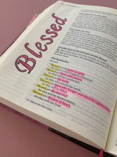 an open book with words written in pink and yellow on it's pages that spell out the word blessing