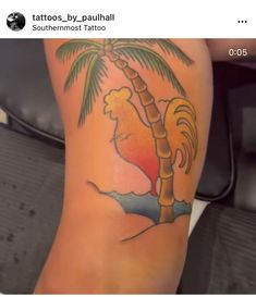 a person with a tattoo on their leg that has a rooster and palm tree on it