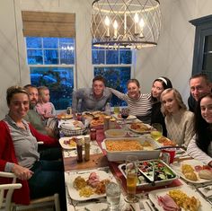 a group of people sitting around a table with food