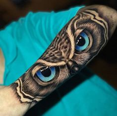 an owl with blue eyes is on the arm