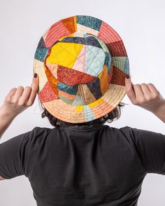 a person wearing a hat made out of different colored pieces of cloth on their head