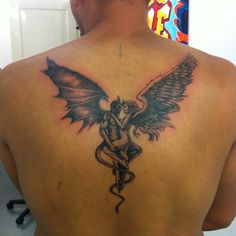 a man with a tattoo on his back has a snake and wings on his back