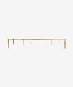 a gold metal shelf with three hooks on the top and two bars at the bottom