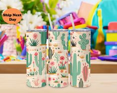 three tumblers with cactus designs on them sitting on a table in front of colorful chairs