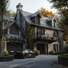 a black sports car parked in front of a large stone house with ivy covered windows