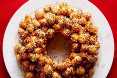 a white plate topped with a bundt cake covered in sprinkles on top of a red table