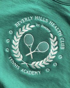 a green t - shirt with the words beverly hills health club and two tennis rackets