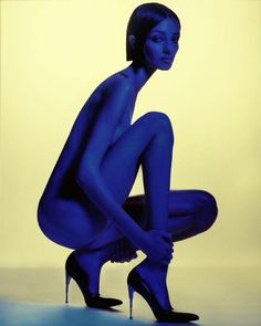 a woman in blue is kneeling down with her legs crossed