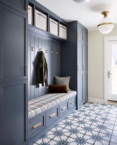 a bench in the middle of a room with blue cabinets and white tiles on the floor