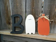 two halloween decorations are sitting on a shelf next to the letter b and a ghost