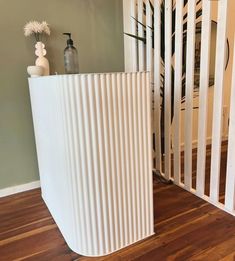 a white sculpture sitting on top of a wooden floor next to a baby crib