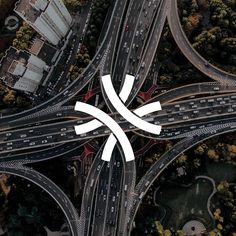 an aerial view of two intersecting roads with arrows pointing in opposite directions and buildings on the other side