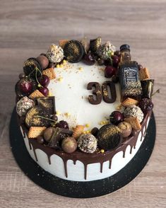 a cake with chocolate icing and nuts on top that says u3c in the middle