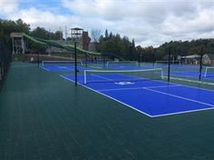 an outdoor tennis court with blue tarps