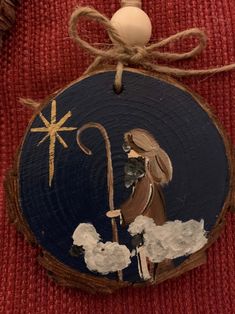 a wooden ornament with an image of a shepherd and a star on it