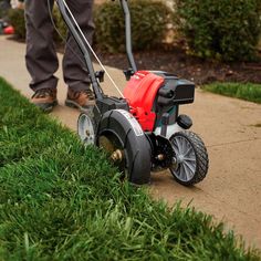 a man mowing the grass with a lawnmower