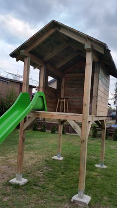 a small wooden structure with a green slide