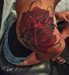 a woman's stomach with tattoos on it and roses painted on the bottom half