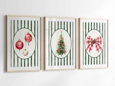 three framed christmas cards hanging on the wall in front of a white wall with green and red stripes