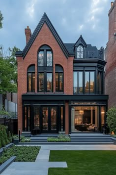 a large brick house with lots of windows on it's side and grass in the front yard