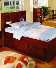 a bed room with a neatly made bed and wooden furniture on the hardwood flooring