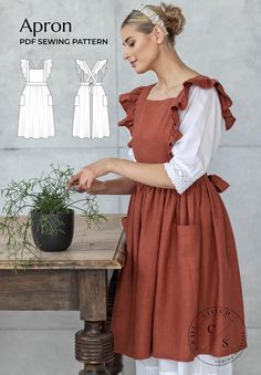 a woman wearing an apron and holding a potted plant in front of a wooden table