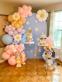 a room filled with balloons and cake on top of wooden flooring next to a window