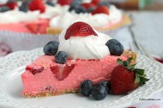 a slice of strawberry cream pie on a white plate with blueberries and strawberries