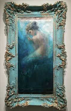 a painting on display in a blue frame